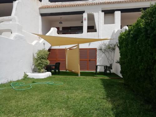 a garden with a yellow umbrella on the grass at Two Lofts in Matalascañas