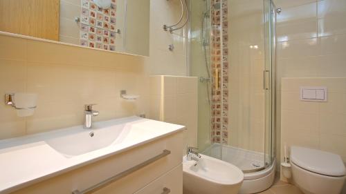 a bathroom with a sink and a toilet and a shower at Apartments Vinka in Jelsa