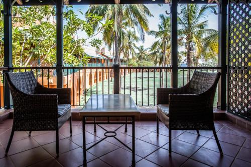 a patio with chairs and a table and a balcony at Avani Pemba Beach Hotel in Pemba