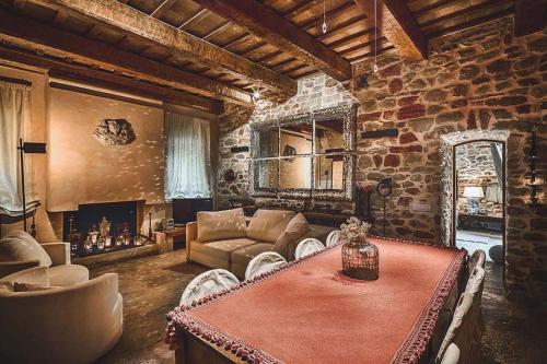 a living room with a table and a stone wall at MarcheAmore - La Roccaccia relax, art & nature in Montefortino