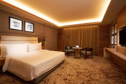 a hotel room with a bed and a table at The Residency Towers Puducherry in Puducherry