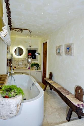 a bath tub with a bench in a bathroom at MarcheAmore - La Roccaccia relax, art & nature in Montefortino