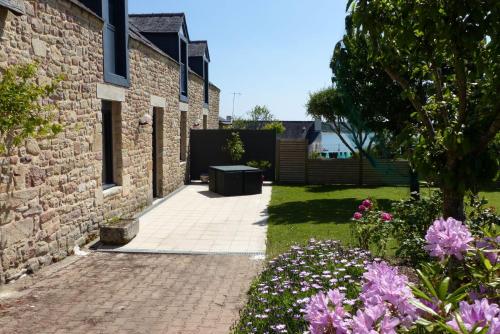 a brick building with a brick walkway and flowers at Baden - Maison 4 personnes avec jardin et vue sur mer in Baden
