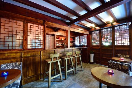 a restaurant with wooden walls and tables and windows at Jingshan Garden Hotel in Beijing