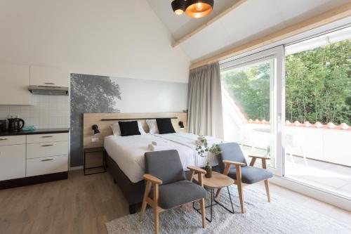 - une chambre avec un lit et une grande fenêtre dans l'établissement Hofstede Moesbosch I Kloeg Collection, à Koudekerke