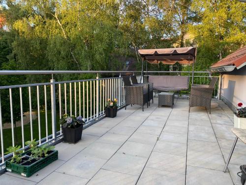 a patio with chairs and a table and an umbrella at Fam M&H Schönes Zimmer Vermieten in Wangen Im Allgäu in Wangen im Allgäu