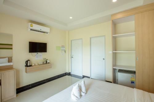 a bedroom with a white bed and a tv at Ioon Resort ไออุ่นรีสอร์ท in Sara Buri