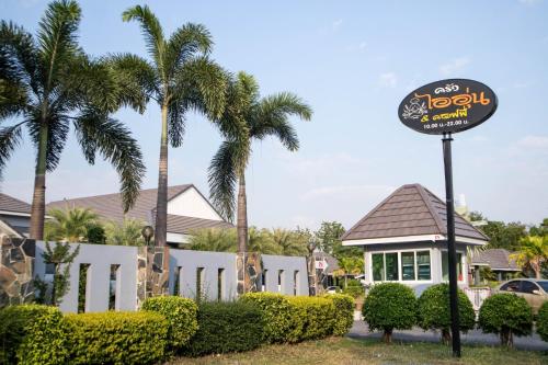 a sign in front of a hotel with palm trees at Ioon Resort ไออุ่นรีสอร์ท in Sara Buri