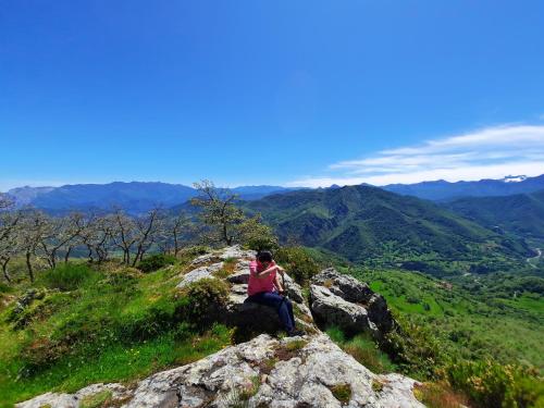 a person sitting on a rock on a mountain at Hosteria Picos De Europa in Potes