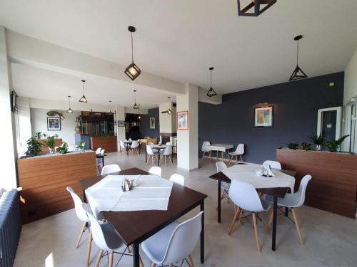 a dining room with tables and white chairs at Willa Orle Gniazdo in Szczyrk