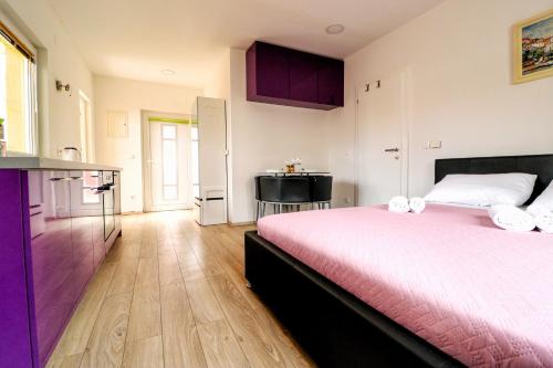 a bedroom with a large bed and a kitchen at Dida Boža House in Vodice