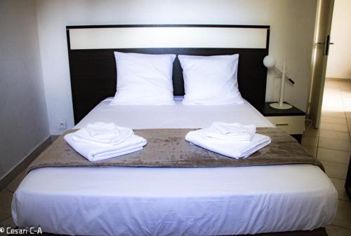 a bedroom with a bed with two towels on it at Résidence de Filitosa - Le Torréen in Sollacaro