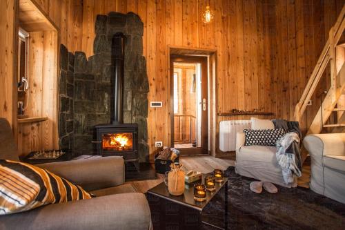 a living room with a fireplace in a log cabin at HelloChalet - Chalet D'Alpage Larose - a wild back mountain escape, large sunny garden and Matterhorn views in Valtournenche