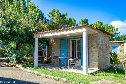 a small stone house with a table and a pergola at Résidence de Filitosa - Le Torréen in Sollacaro
