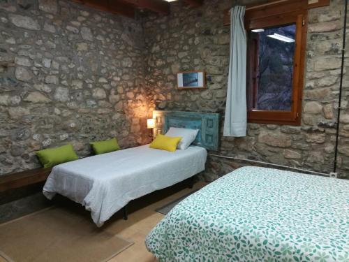 Tempat tidur dalam kamar di Alberg Rural La Rectoria de Pedra