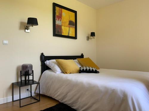 a bedroom with a bed with a yellow pillow at Maison de vacances près de Marciac in Troncens
