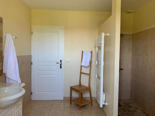 a bathroom with a sink and a white door at Maison de vacances près de Marciac in Troncens
