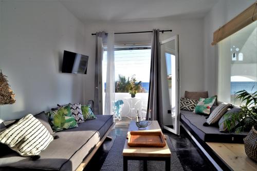 a living room with a couch and a table at Aloe Mare Suites in Liaropá