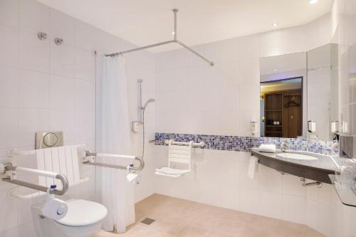 a bathroom with a toilet, sink, and bathtub at Holiday Inn Express Bremen Airport, an IHG Hotel in Bremen