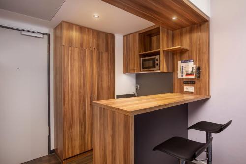 a kitchen with a counter with a microwave and a stool at Holiday Inn Express Bremen Airport by IHG in Bremen