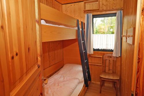 ダンプにあるBlockhaus _ zentral zum Hafen_ Strの小さな客室で、二段ベッド1組、椅子が備わります。