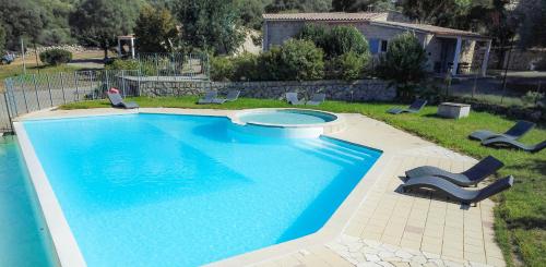 a large swimming pool with chairs in a yard at Résidence de Filitosa - Le Torréen in Sollacaro