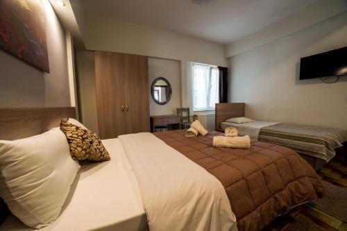 een hotelkamer met 2 bedden en een televisie bij Stalaktites in Ioannina
