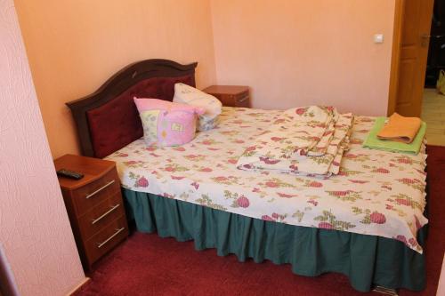 ein Schlafzimmer mit einem Bett mit einem Kopfteil aus Holz in der Unterkunft Квартира-студия in Tschernihiw