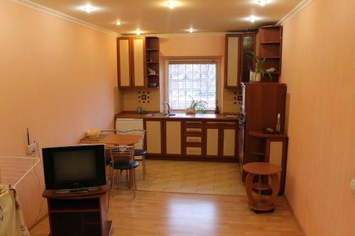 eine Küche mit einem Tisch und einem TV in einem Zimmer in der Unterkunft Квартира-студия in Tschernihiw