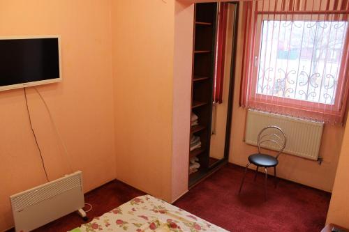 a bedroom with a bed and a tv and a window at Квартира-студия in Chernihiv