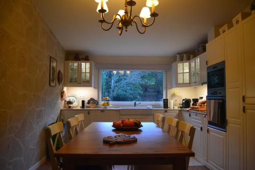 a kitchen with a wooden table and a large window at CASA DO SORRO in Ponte de Lima