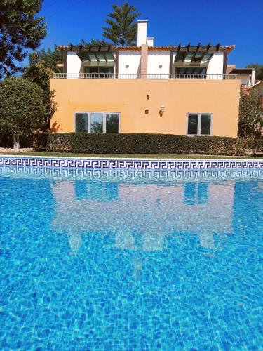 a house with a swimming pool in front of a building at Quinta dos Caracois in Lagos
