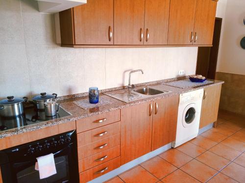 a kitchen with a sink and a washing machine at Quinta dos Caracois in Lagos