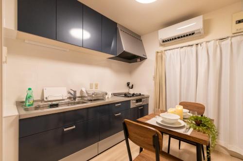 a kitchen with a wooden table and a dining room at AGURIHOME Hayashiji in Osaka