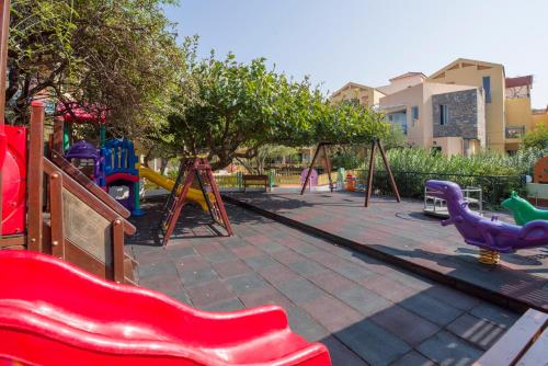 a playground with play equipment in a park at Stefan Village Hotel in Agia Marina Nea Kydonias