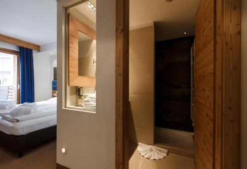 ein Hotelzimmer mit einem Bett und einem TV in der Unterkunft Falkensteiner Club Funimation Katschberg in Katschberghöhe