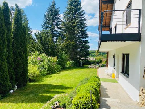 a garden next to a building with a lawn and trees at Enjoy Hiking in Aufseß