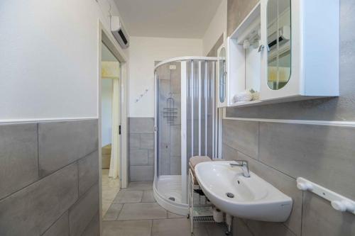 a white bathroom with a sink and a toilet at Albergo Luisss in Marina di Grosseto
