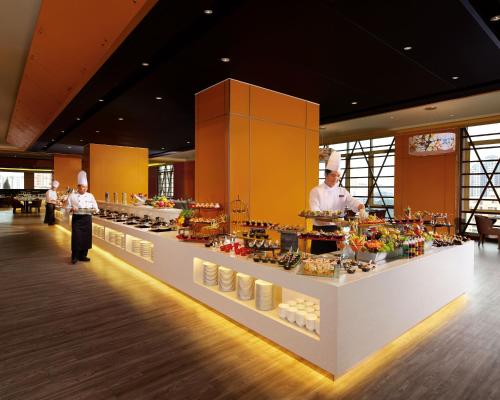 a kitchen with two chefs standing in front of a buffet at Sunway Lagoon Hotel , formerly Sunway Clio Hotel in Kuala Lumpur