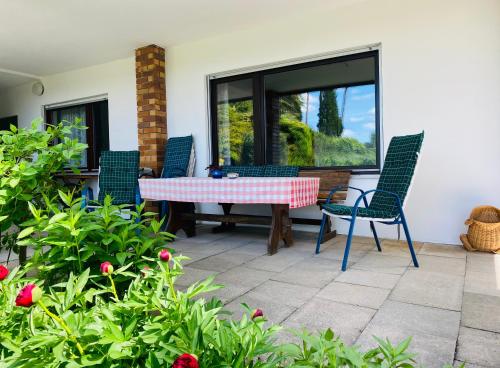 patio con mesa, sillas y ventana en Enjoy Hiking en Aufseß