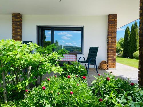 a patio with a chair and some bushes at Enjoy Hiking in Aufseß