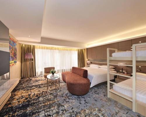 um quarto de hotel com um beliche e uma cadeira em Sunway Pyramid Hotel em Kuala Lumpur
