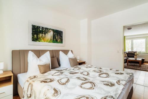 - une chambre avec un grand lit aux murs blancs dans l'établissement Bode_Apartments, à Elend