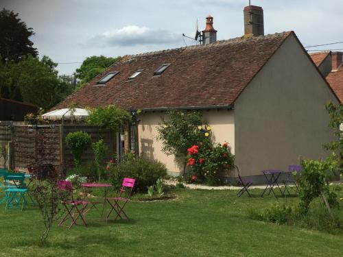 a house with chairs and tables in a yard at Chantilly ,petit déjeuner et table d'hôtes possible in Noyers