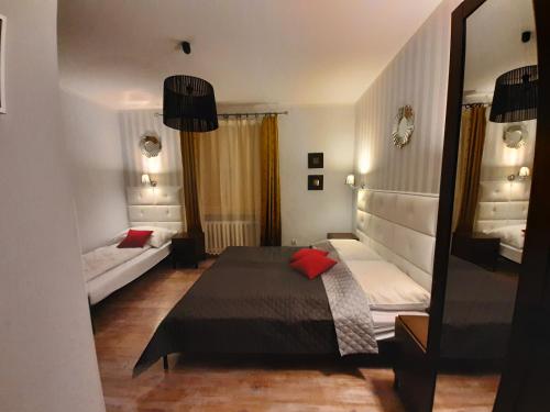 um pequeno quarto com uma cama e um espelho em Villa Senso em Busko-Zdrój