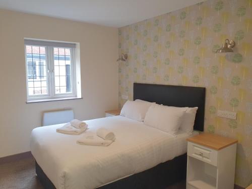 a bedroom with a bed with towels on it at The Bournbrook Inn in Birmingham