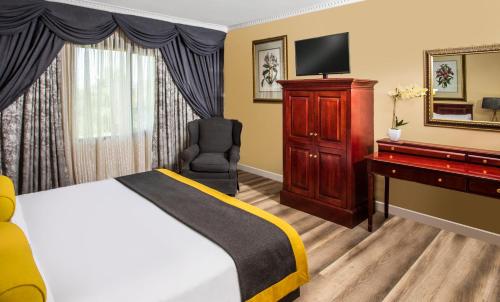 a hotel room with a bed and a desk and a television at Avani Gaborone Resort & Casino in Gaborone