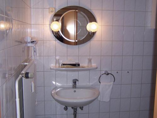 a white bathroom with a sink and a mirror at Hotel Post in Kelkheim