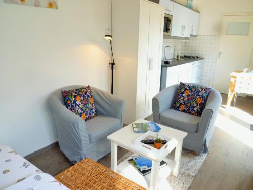 een woonkamer met 2 stoelen en een tafel bij DO27 Charmante Studio in Domburg in Domburg