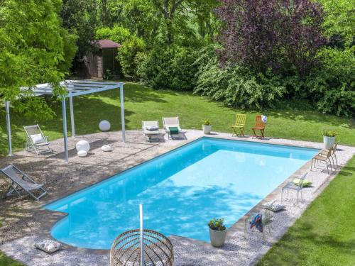 a swimming pool in a yard with chairs at Belvilla by OYO Camelle in Fermignano